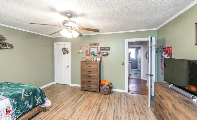 bedroom with ceiling fan, light hardwood / wood-style flooring, a textured ceiling, and ornamental molding