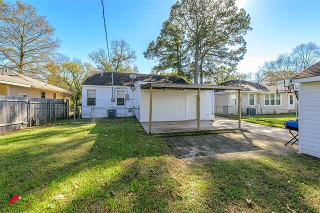 rear view of house with a lawn, cooling unit, and a patio