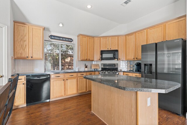 kitchen featuring dark wood-type flooring, black appliances, vaulted ceiling, dark stone countertops, and a kitchen island