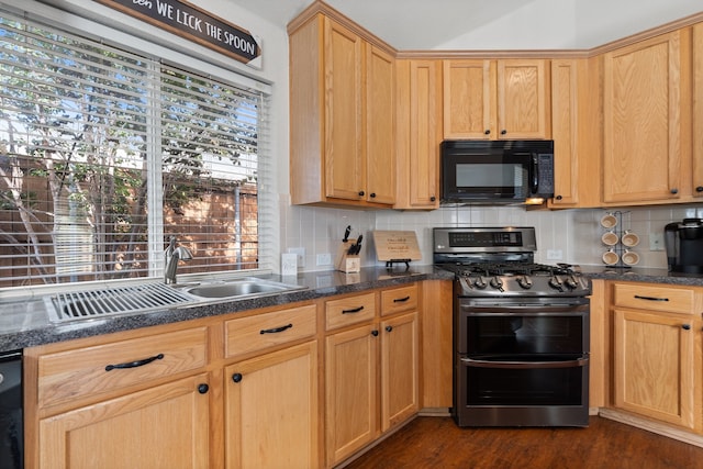 kitchen with dark hardwood / wood-style floors, stainless steel gas range oven, decorative backsplash, and sink