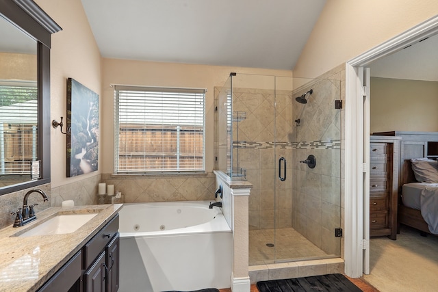 bathroom featuring a wealth of natural light, vanity, vaulted ceiling, and shower with separate bathtub