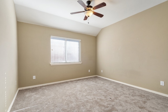 spare room featuring light carpet, vaulted ceiling, and ceiling fan