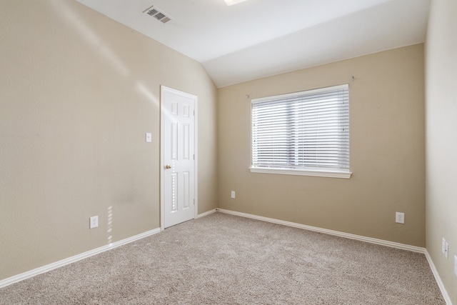 carpeted empty room featuring lofted ceiling