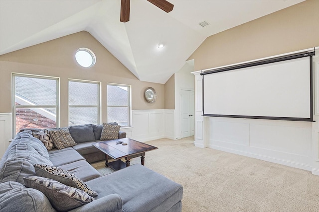 cinema with ceiling fan, vaulted ceiling, and light carpet