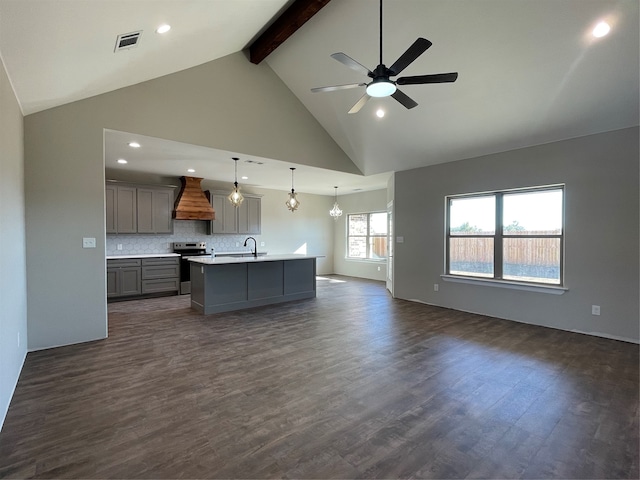 kitchen with dark hardwood / wood-style flooring, premium range hood, electric stove, pendant lighting, and an island with sink