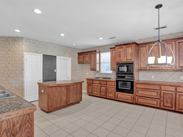 kitchen featuring a center island, sink, hanging light fixtures, light tile patterned flooring, and black appliances