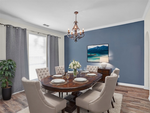 dining space featuring hardwood / wood-style flooring, a notable chandelier, and ornamental molding