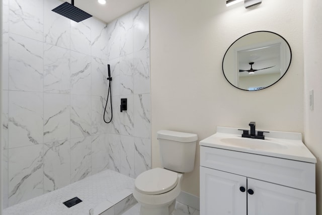 bathroom featuring tiled shower, ceiling fan, vanity, and toilet