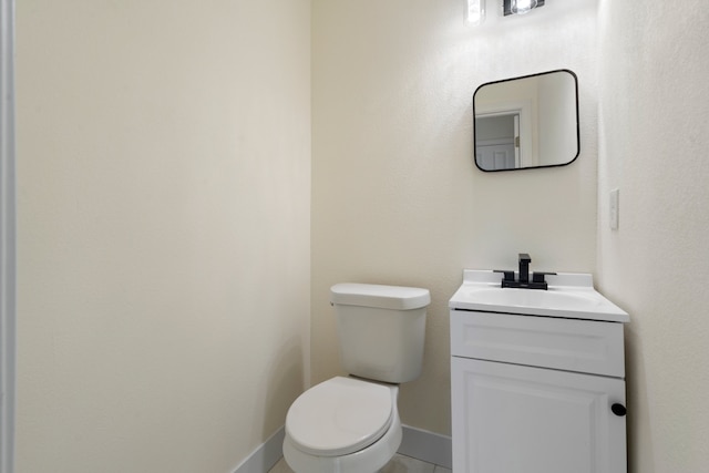 bathroom with tile patterned flooring, vanity, and toilet