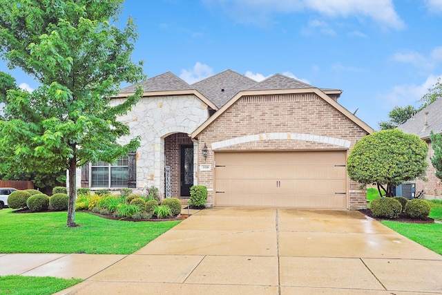 view of front of home with a front yard, a garage, and central AC unit