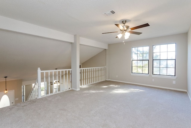 carpeted empty room with a textured ceiling, ceiling fan, and vaulted ceiling