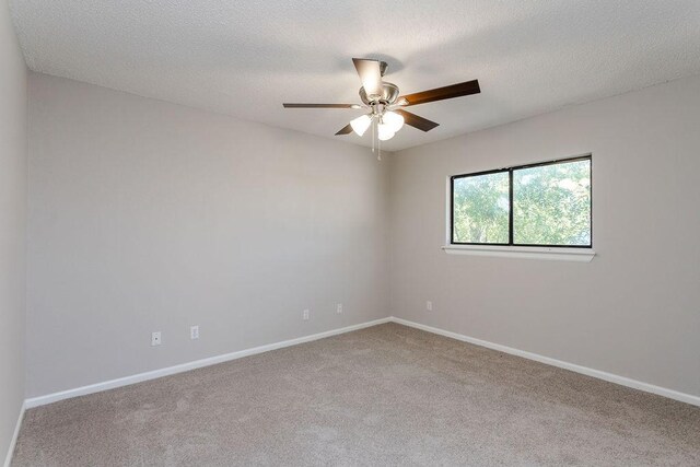 carpeted empty room featuring ceiling fan and a textured ceiling