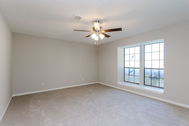 unfurnished room featuring carpet, ceiling fan, and a textured ceiling