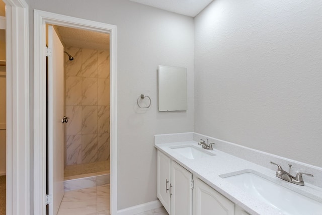 bathroom featuring a tile shower and vanity