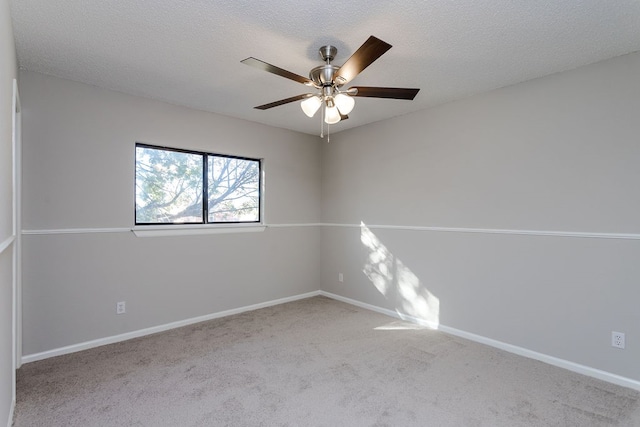 spare room featuring ceiling fan, light colored carpet, and a textured ceiling