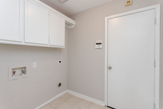 clothes washing area with cabinets, hookup for a washing machine, a textured ceiling, electric dryer hookup, and light tile patterned floors