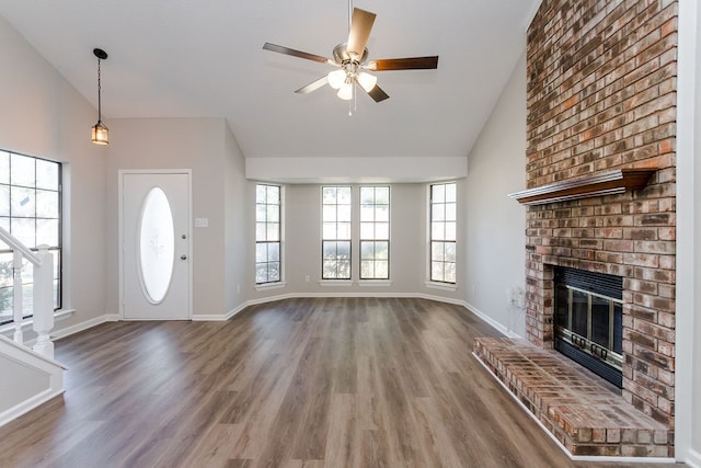 unfurnished living room with a fireplace, ceiling fan, hardwood / wood-style floors, and lofted ceiling