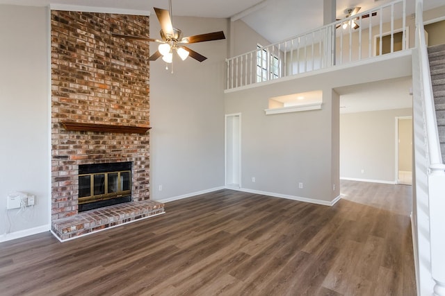 unfurnished living room featuring a fireplace, ceiling fan, dark hardwood / wood-style flooring, and high vaulted ceiling