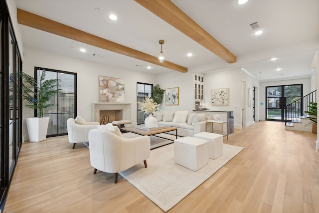 living room featuring beamed ceiling and light wood-type flooring