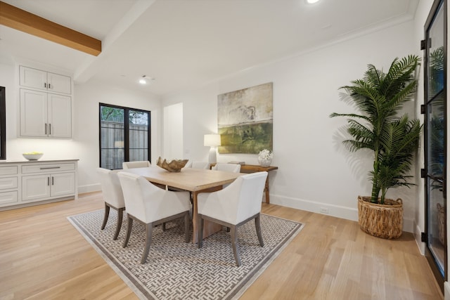 dining space featuring beam ceiling and light wood-type flooring