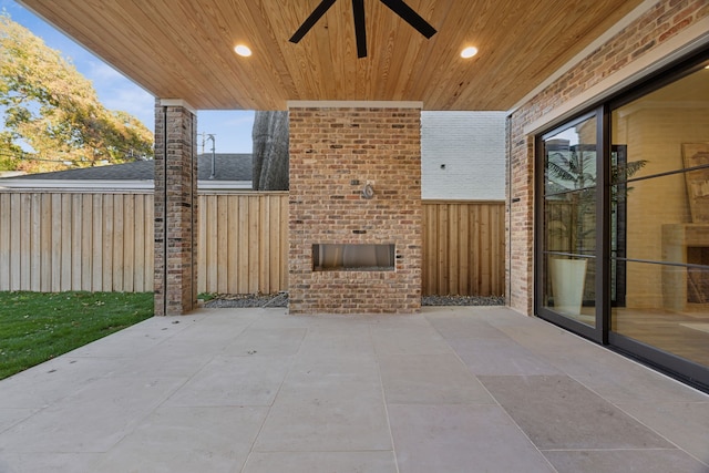 view of patio / terrace with ceiling fan and an outdoor fireplace