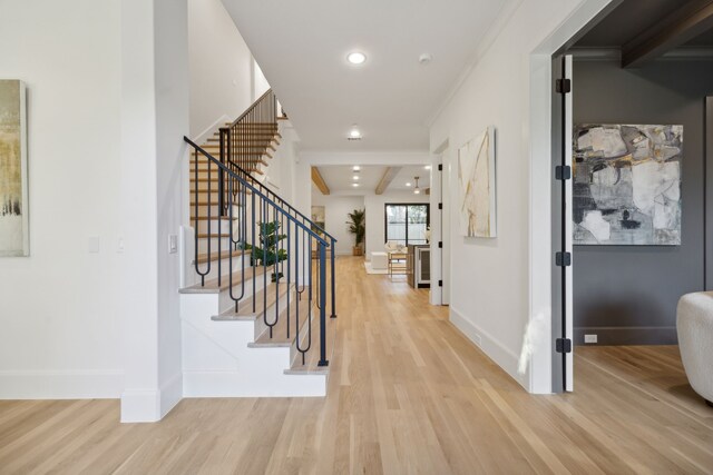 entryway with crown molding, light hardwood / wood-style flooring, and beamed ceiling