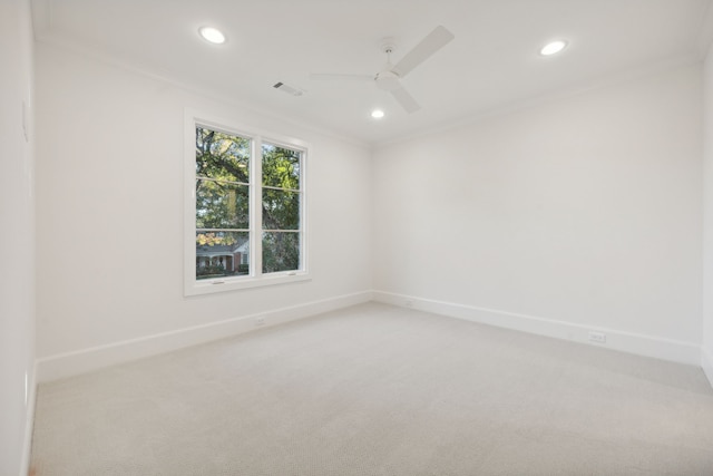 carpeted spare room featuring ceiling fan and crown molding