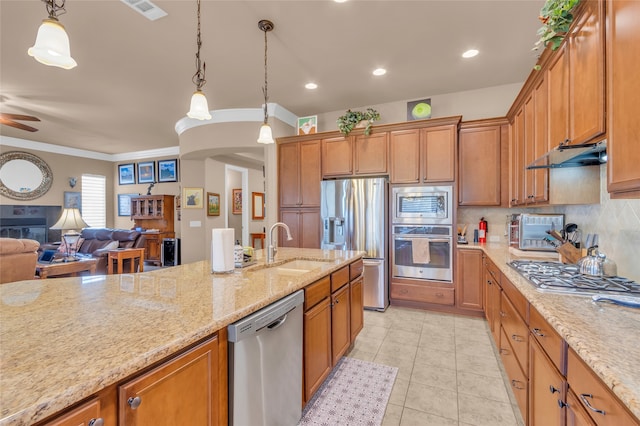 kitchen featuring pendant lighting, stainless steel gas stovetop, crown molding, and sink