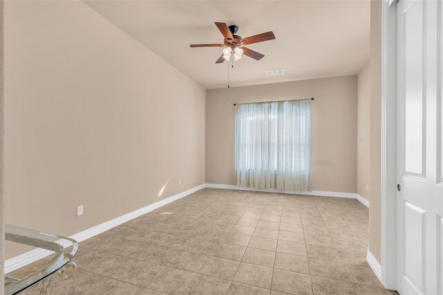 tiled empty room featuring ceiling fan