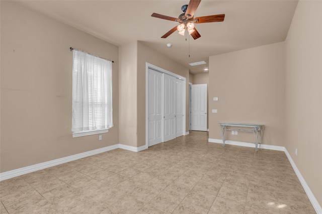 unfurnished bedroom with ceiling fan and a closet