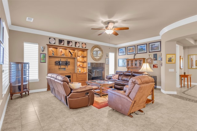 living room featuring light tile patterned floors, ceiling fan with notable chandelier, and ornamental molding