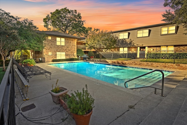 pool at dusk with a patio