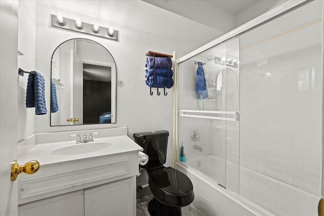 full bathroom featuring vanity, bath / shower combo with glass door, and toilet