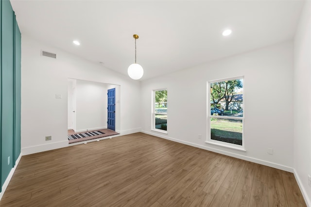 empty room featuring dark hardwood / wood-style flooring and vaulted ceiling