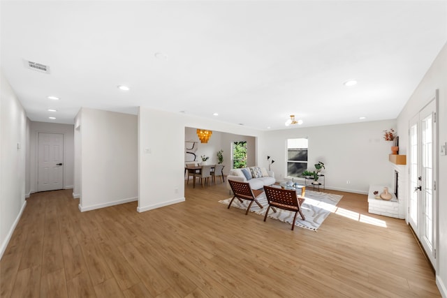 interior space featuring an inviting chandelier, light hardwood / wood-style flooring, and a healthy amount of sunlight