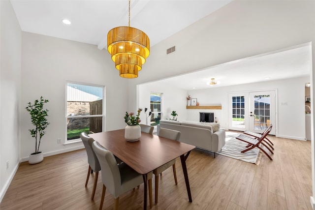 dining space featuring plenty of natural light, light hardwood / wood-style floors, and french doors