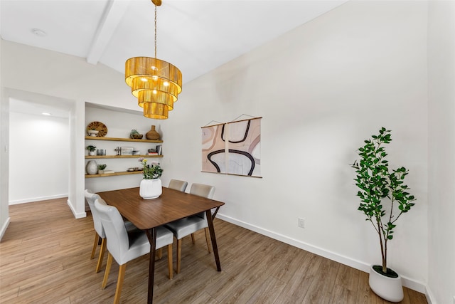 dining room with vaulted ceiling with beams, an inviting chandelier, and light hardwood / wood-style flooring