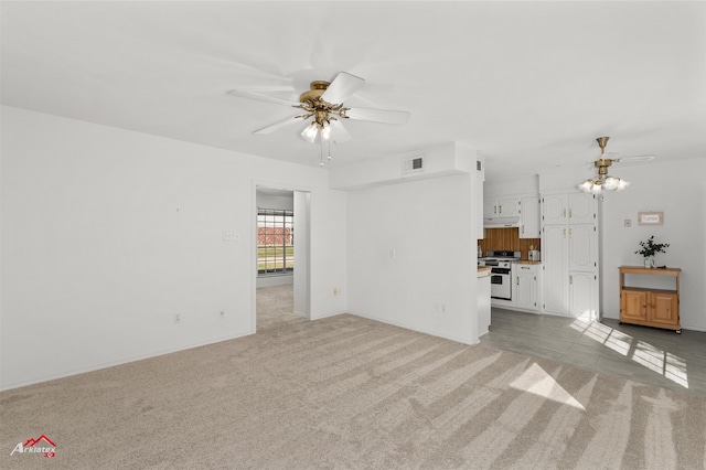 unfurnished living room featuring light colored carpet and ceiling fan