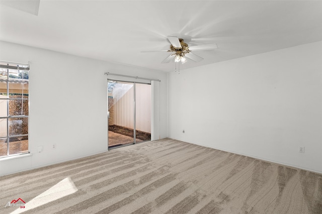 carpeted spare room with ceiling fan