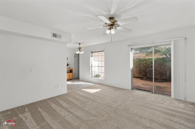 unfurnished living room featuring ceiling fan with notable chandelier and light carpet