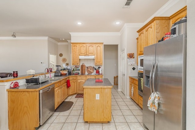 kitchen featuring kitchen peninsula, appliances with stainless steel finishes, crown molding, light brown cabinets, and a center island