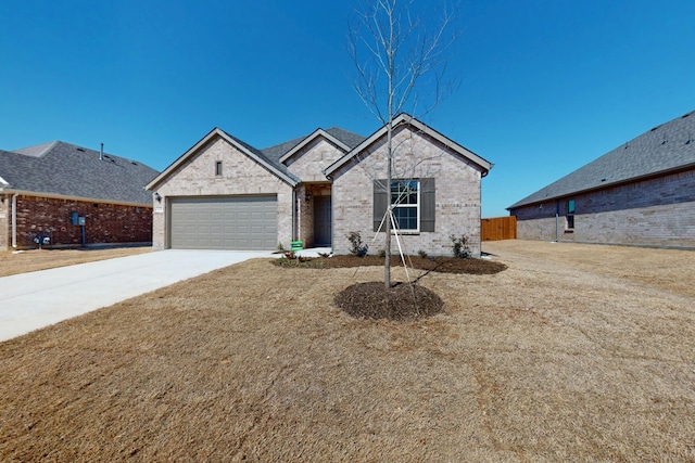 view of front of property with a garage, a front yard, brick siding, and driveway