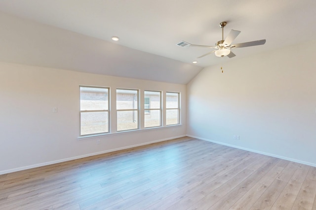 spare room with a ceiling fan, baseboards, vaulted ceiling, and light wood finished floors