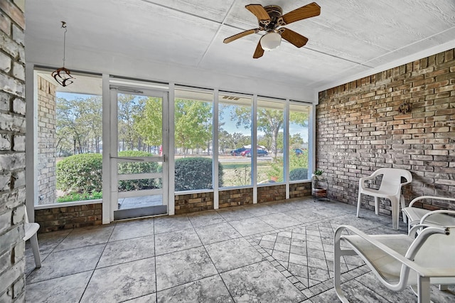 unfurnished sunroom featuring ceiling fan