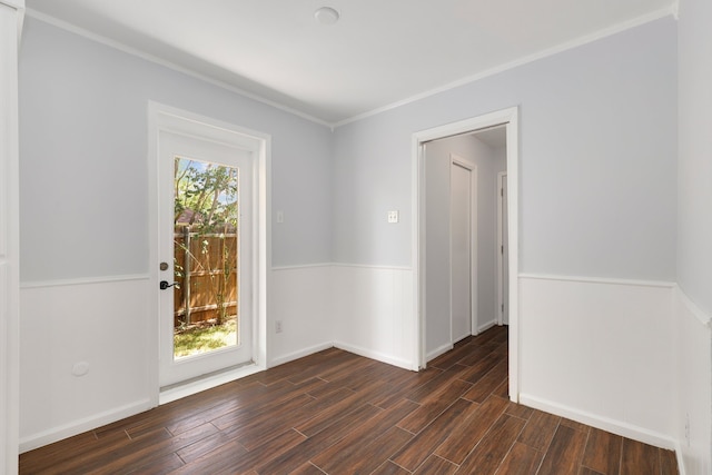 empty room featuring ornamental molding and dark wood-type flooring