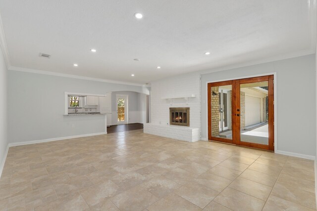 unfurnished living room with crown molding, light tile patterned floors, and a brick fireplace