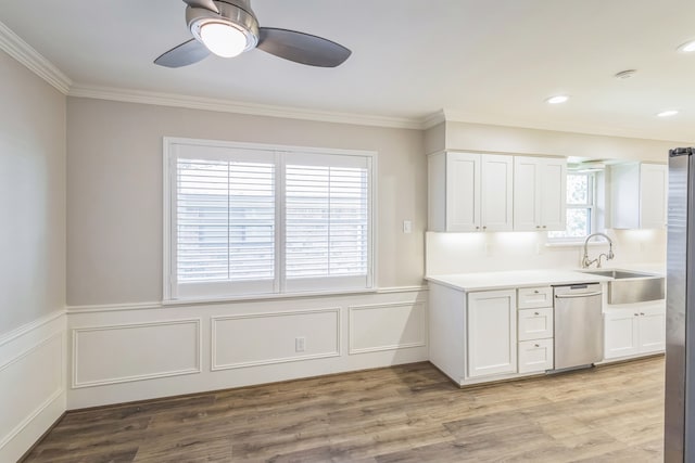 kitchen featuring white cabinets, sink, crown molding, light hardwood / wood-style flooring, and stainless steel appliances