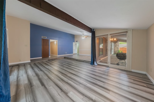 empty room featuring beamed ceiling, light hardwood / wood-style floors, and ceiling fan