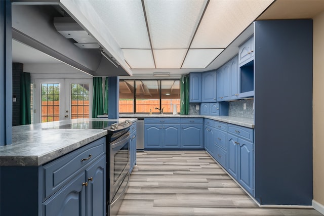 kitchen featuring decorative backsplash, french doors, light hardwood / wood-style flooring, and blue cabinets