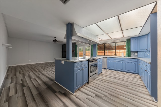 kitchen with ceiling fan, light wood-type flooring, blue cabinetry, appliances with stainless steel finishes, and kitchen peninsula